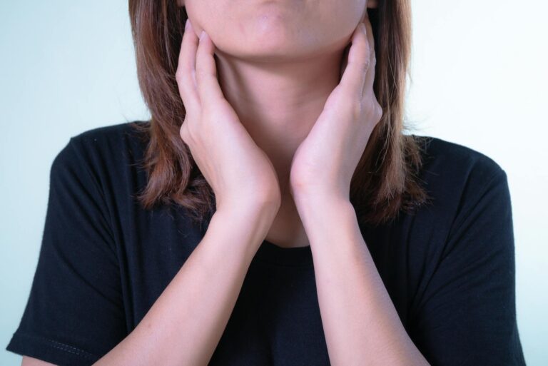 close up of woman touching her tonsils