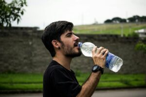 man wearing black shirt drinking water